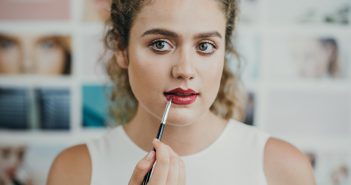 Quel maquillage porter pour séduire lors d’un premier rendez-vous ? Une femme entre de se maquiller les lèvres