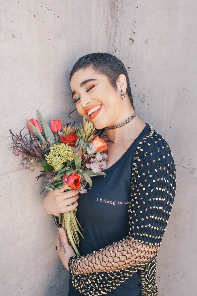 Une jeune femme qui sourit avec un bouquet de fleurs